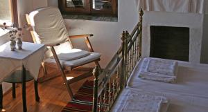 een kamer met een stoel, een bed en een tafel bij Guesthouse Parthenon in Parthenón