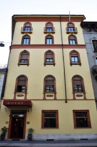 a tall yellow building with windows at Hotel San Guido in Milan