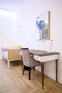 a desk with a chair and a mirror and a bed at Megapolis Luxury Suites in Sarajevo
