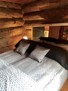 łóżko w pokoju z drewnianą ścianą w obiekcie Villa Karhuntähti w mieście Luosto