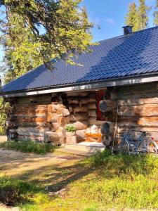 una cabaña de madera con una bicicleta estacionada fuera de ella en Villa Karhuntähti, en Luosto