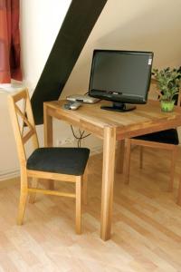escritorio de madera con monitor de ordenador y silla en Gästehaus Oh-La-La en Wilster