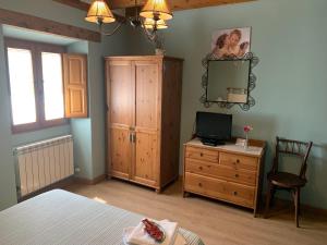 a bedroom with a bed and a dresser and a mirror at La Cabala de Ibeas in Ibeas de Juarros