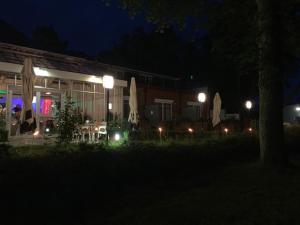 a building at night with lights in front of it at Hotel Seegarten in Barmstedt