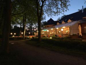 a building with lights in front of it at night at Hotel Seegarten in Barmstedt