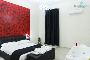 1 dormitorio con cama, bañera y pared roja en Essential Suite B&B Botanic en Nápoles