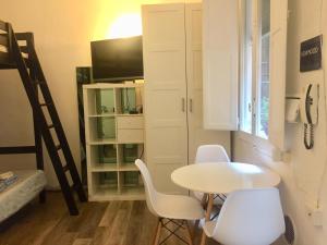 Camera piccola con tavolo, sedie e TV di Portici di via Piella (monolocale) a Bologna