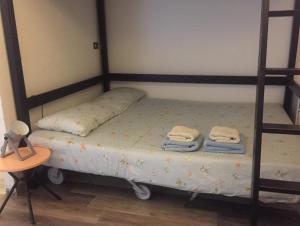 una camera con due letti a castello e asciugamani di Portici di via Piella (monolocale) a Bologna