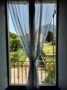 ventana con cortina y vistas a un parque infantil en Tra la Stazione e il Lago en Verbania