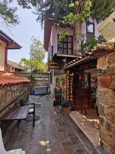 a woman standing on a street in front of a building at Sultan Pension in Antalya