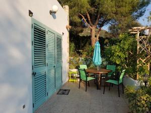 a patio with a table and chairs and an umbrella at Casa Prescilia in Lumio
