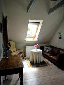 a living room with a table with a flower on it at Hvirrekærgaard, midt i naturen. in Hirtshals