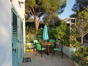 a patio with a table and chairs and an umbrella at Casa Prescilia in Lumio