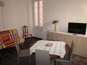 a living room with a table and a tv at CASA ROSSA in Borgomaro