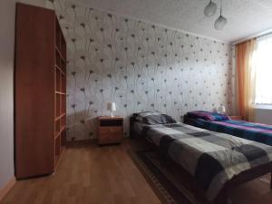 a bedroom with two beds and a wall with a pattern at Apartament nr 3 w Starym Nadleśnictwie in Kościerzyna