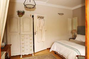 - une chambre avec un lit et une commode dans l'établissement Oleander Guest House, à Kimberley