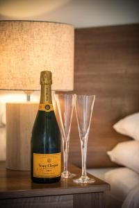 una bottiglia di champagne e due bicchieri su un tavolo di Bayview Farm Holiday Cottages a Bushmills