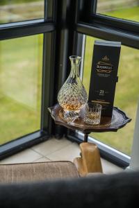 un jarrón sentado en una mesa junto a una ventana en Bayview Farm Holiday Cottages, en Bushmills