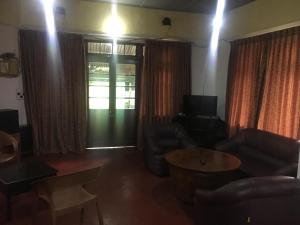 a living room with a couch and chairs and a table at Devon Fall Cottage in Dimbula