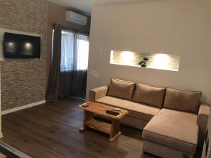 a living room with a couch and a coffee table at Apartments The Old Well in Gornji Vaganac