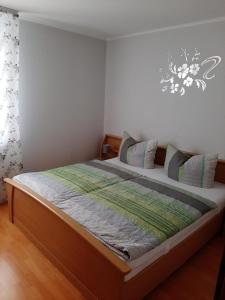 ein Schlafzimmer mit einem großen Bett mit einem Holzrahmen in der Unterkunft Ferienwohnungen Wittmann in Bad Staffelstein