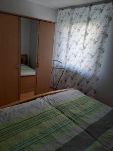 ein Schlafzimmer mit einem Bett, einer Kommode und einem Fenster in der Unterkunft Ferienwohnungen Wittmann in Bad Staffelstein