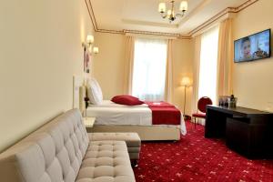 a hotel room with a bed and a couch at Top Royal Central Brasov in Braşov