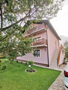 a pink house with a balcony and a yard at Apartment Arena Zagreb in Zagreb