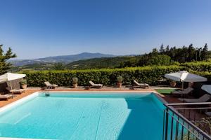 - une piscine avec des chaises et des parasols à côté dans l'établissement Si Montalcino Hotel, à Montalcino