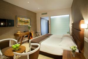a hotel room with a bed and a table and a desk at Faros Hotel Ayia Napa in Ayia Napa