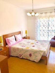 ナザレにあるApartamento Arte Xávegaのベッドルーム1室(ピンクのシーツが敷かれたベッド1台、窓付)