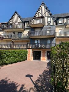 a large building with balconies on the side of it at Appartement Rez de jardin Cabourg résidence bord de mer in Cabourg