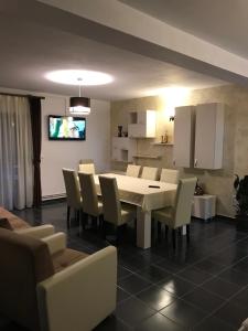 a dining room with a white table and chairs at Casa Larisa in Chişcău