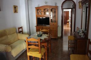 sala de estar con mesa y TV en Casa Manolito, en Prado del Rey