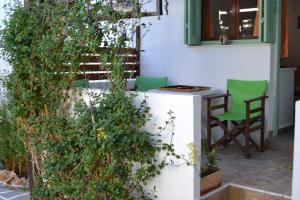 um pátio com uma mesa, cadeiras e plantas em Skyros Koxilas Studios em Skiros