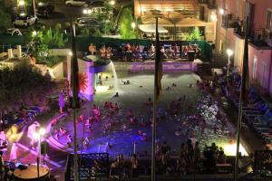 grupa ludzi w basenie w nocy w obiekcie HOTEL TERME MARINO w mieście Ali Terme