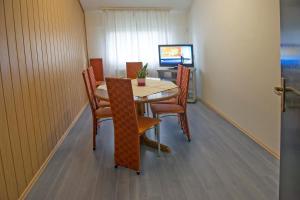 ein Esszimmer mit einem Tisch, Stühlen und einem TV in der Unterkunft Hostel M in Maribor