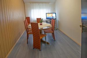 a dining room with a table and chairs and a television at Hostel M in Maribor