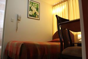 Habitación de hotel con cama y teléfono en la pared en La Almohada del Rey, en Arequipa