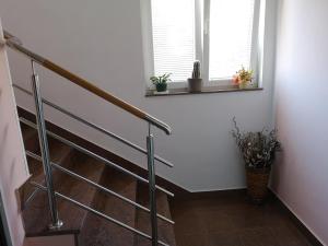 een trap in een kamer met twee ramen en planten bij Apartment Marica in Brodarica