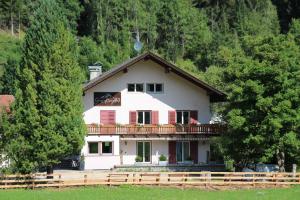 a large white house with a balcony and trees at Garni Bergblick in Braies