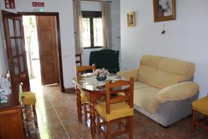 ein Wohnzimmer mit einem Tisch und einem Sofa in der Unterkunft Casa Manolito in Prado del Rey