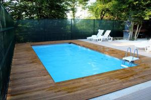 a pool with a wooden deck and a swimming pool at "DreamHome Mušić" Rasavci in Prijedor