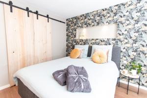 una camera da letto con un letto bianco e una parete con accenti floreali di Eindhoven Inn a Eindhoven