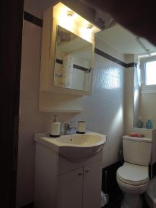 Un baño con lavabo, inodoro y espejo. en Konba luxury mini apartment, en Tesalónica