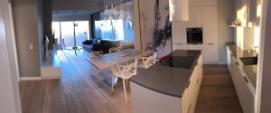 a kitchen and living room with a table and chairs at Vantage Point Apartament Sky Tower in Wrocław