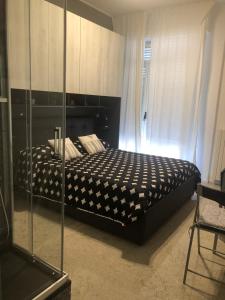 1 dormitorio con 1 cama y pared de cristal en B&B Calypso, en Pescara