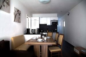 una pequeña cocina con mesa de madera y sillas en TownVille, en Flachau 27 fotos más