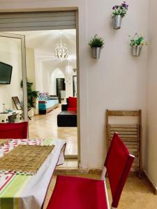 a living room with a table and red chairs at Marina Saidia AP8 LILIA in Saïdia