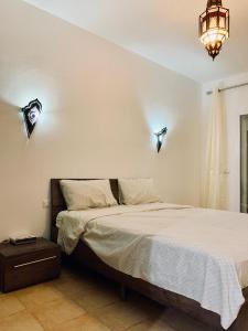 a bedroom with a bed and lights on the wall at Marina Saidia AP8 LILIA in Saïdia